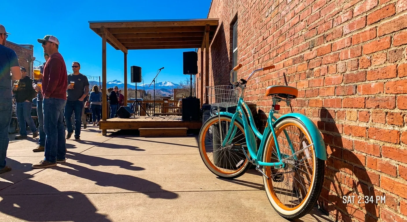A bicycle leans against a brick brewery wall in Fort Collins with an outdoor stage in the background.